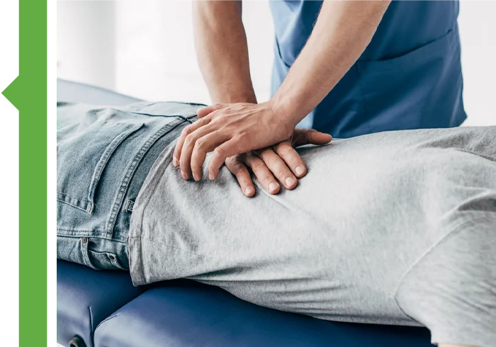 Hands applying pressure to a person’s lower back