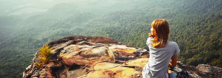 Person sitting on a rocky cliff