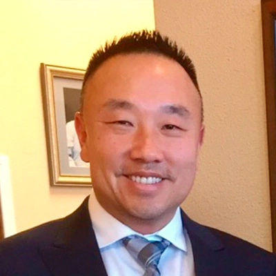 Close-up of a person wearing dark scrubs standing indoors